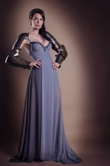 portrait of a beautiful lady warrior, dark-haired girl in a gray dress.