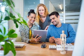Smiling business team working together with tablet 