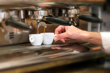 Fototapeta na wymiar Man working in a coffee house preparing espresso