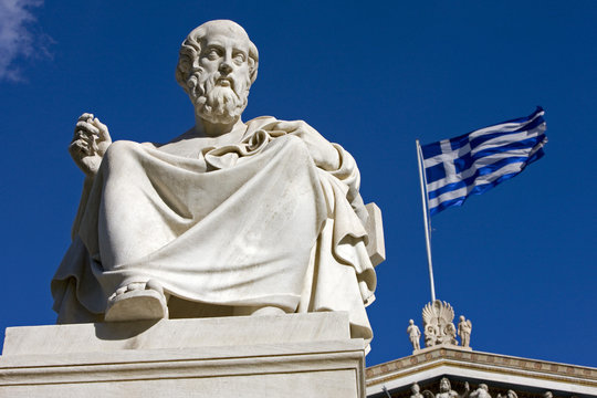 Statue of Greek philosopher Plato and greek flag.