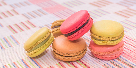 Sweet and colourful french macaroons on cotton cloth background.