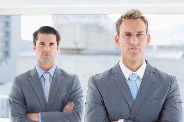 Two businessmen frowning at camera