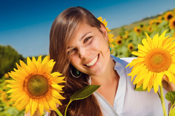 young beautiful woman between sunflowers