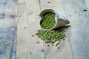 Mung beans in sack on vintage wooden boards