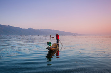 Local fishermen are fishing by boat in unique style, Inle lake, Myanmar
