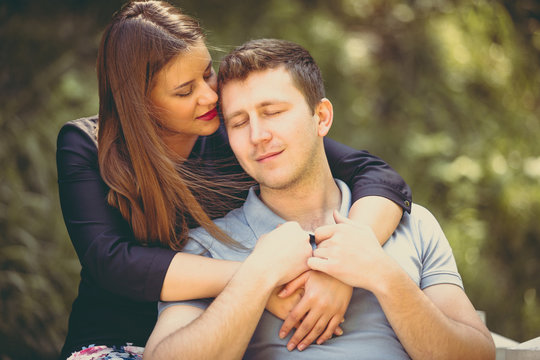 Toned portrait of beautiful woman hugging boyfriend at park