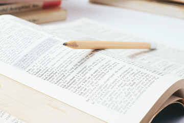 Open dictionary with  pencil