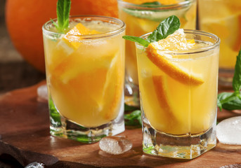 Refreshing cocktail with soda, orange, mint and ice, selective f