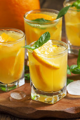 Refreshing cocktail with soda, orange, mint and ice, selective f