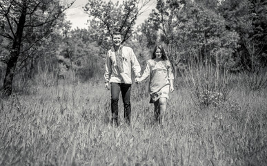 couple in love in traditional ukrainian clothes walking at meado