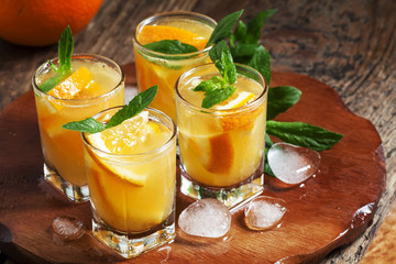 Refreshing cocktail with soda, orange, mint and ice, selective f