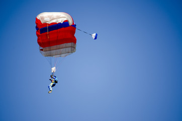 Colorful red white parachute on clear blue sky