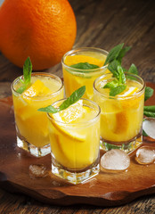 Refreshing cocktail with soda, orange, mint and ice, selective f