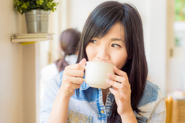 Woman with cup of coffee smiling in cafe