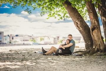 Toned photo of beautiful couple in love relaxing under tree