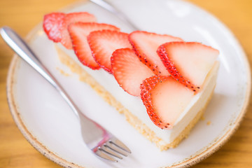Strawberry cake with fork on white plate