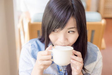 Woman with cup of coffee smiling in cafe
