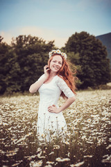 Image of pretty woman lying down on chamomile field, happy femal