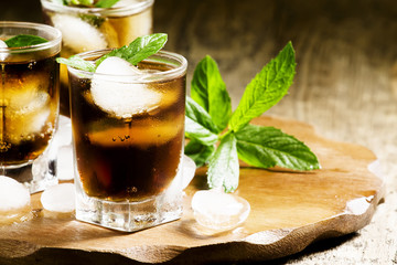 Cuba Libre with mint and ice in a glass, selective focus