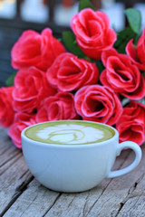 Green tea with milk and artificial flowers.