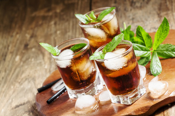 Cuba Libre with mint and ice in a glass, selective focus
