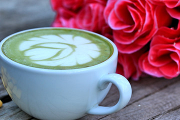 Green tea with milk and artificial flowers.