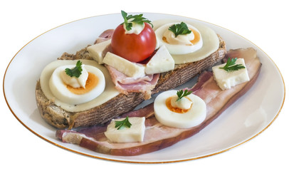 Toast Sandwich on porcelain plate, with Ham, Cheese, Egg slices, Cherry Tomato, Mayonnaise, Parsley leaves, and an extra Pork Bacon Rasher alongside, isolated on White Background.