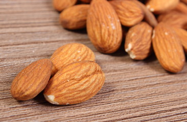 Heap of almonds on wooden background