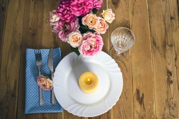 Fototapeta na wymiar Beautiful festive table setting with roses, candles and napkins 