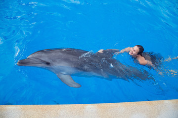Naklejka premium Girl swimming with Dolphin