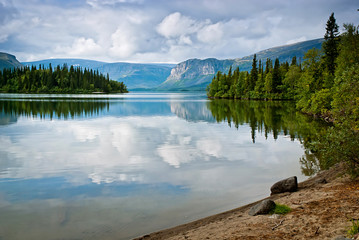 Beautiful tranquil landscape with mountains and reflection of cl