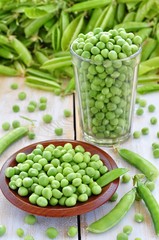 Green peas in a glass on a wooden background