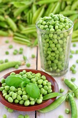 Green peas in a glass on a wooden background