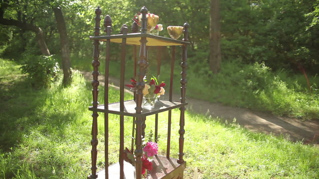 On the antique wooden stand tiny bouquets of roses in glass vases.