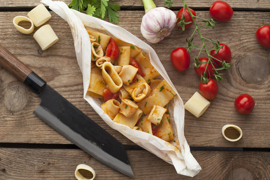 Calamarata dish with ingredients on wooden surface