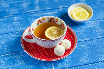 lemon tea in a vintage Cup and candy on a blue background