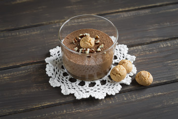 chocolate mousse with nuts and biscuits on a dark surface