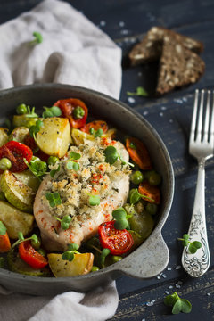 chicken fillet with bread crumbs and baked vegetables in a vintage scourage 