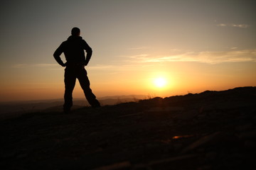 A man watching sunrise from the mountain in Bieszczady Mountains, Poland.