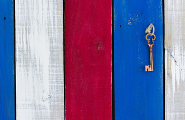 Skeleton key hanging on red, white and blue wood background