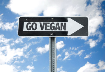 Fototapeta premium Go Vegan direction sign with sky background