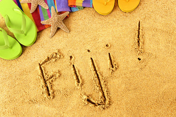 Fototapeta na wymiar Fiji word written in sand on a sandy beach background with star fish and accessories summer tropical holiday vacation photo