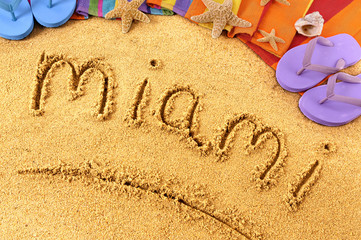 Fototapeta na wymiar Miami word written in sand on a sandy beach background with star fish and accessories summer Florida holiday vacation photo