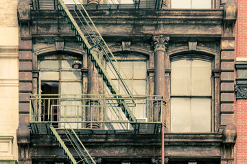 Windows and fire escape on  apartment building with vintage effect