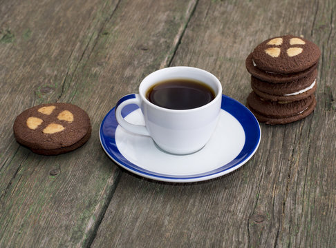 cup of coffee with cookies on the old board