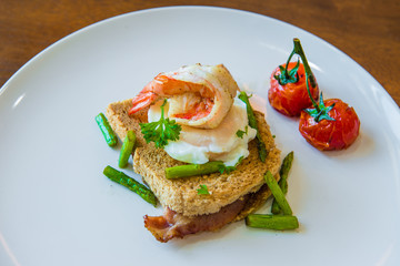 Sandwich with poached egg, parma ham and tomato