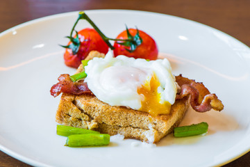 Sandwich with poached egg, parma ham and tomato