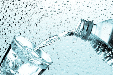 Drinking water is poured from a bottle into a glass