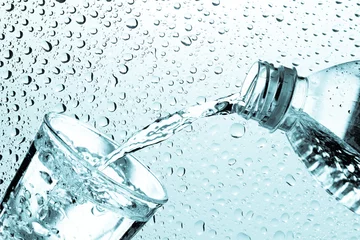 Fototapeten Trinkwasser wird aus einer Flasche in ein Glas gegossen © Love the wind