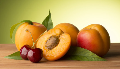 apricots and cherries on the wooden table